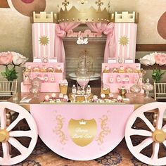 a table with pink and gold decorations on it's sides, including a princess carriage