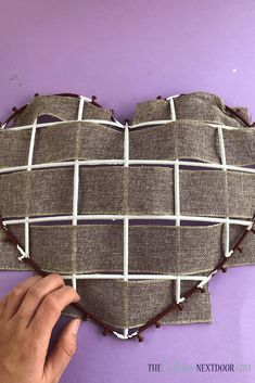 someone is making a heart shaped pillow out of fabric