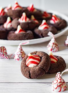 chocolate cookies with candy canes and candies in the middle on a white table