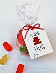 small gummy bears are in a bag with a tag that says a big hug