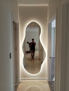 a person is taking a photo in the reflection of a large mirror on the wall