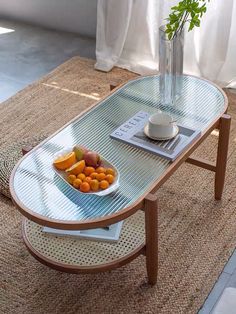 a bowl of fruit is sitting on a coffee table