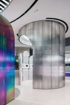 the interior of a modern building with rainbow colored walls and circular metal structure on the floor