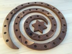 a circular wooden object with holes in the middle and a star on it's side