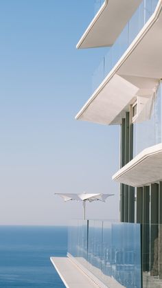 an ocean view from the side of a building with balconies and glass railings