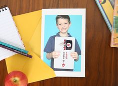 an apple, notepad and pencils are sitting on a desk next to a photo