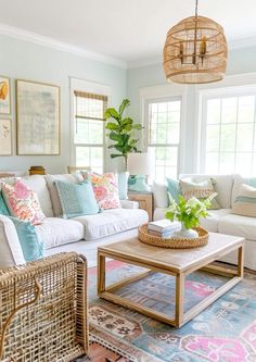 a living room filled with white couches and colorful pillows on top of each other