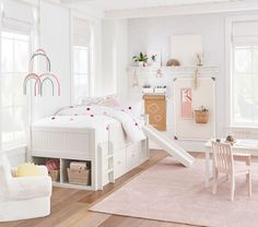 a child's bedroom with white furniture and pink rugs on the hardwood floor