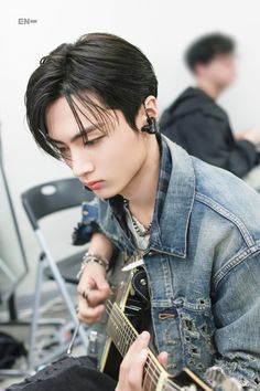 a young man is playing an electric guitar