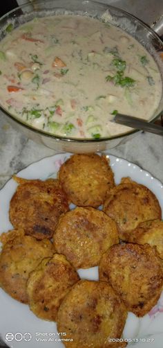 some food is sitting on a plate next to a bowl of soup and another dish