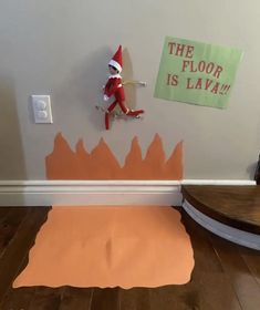 an elf is sitting on the floor in front of a wall with paper cut out