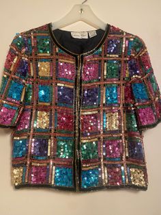 Women's Vintage  "Lawrence Kazar" 1970's  sz small multicolor hand beaded jacket of pale & dark colors in sequins & bugle beads. The square colored boxes of sequins are in Pink, Green, Turquoise, Purple & Gold colors. It closes down the front with hooks & eyes & can be worn open or closed.  Made in India the outside is 100% silk & the lining is 100% polyester. The beading is in very good condition & the jacket is very clean inside & out as in  "hardly worn " .  Approx measurements are:  Pit to pit:  18"  total:   36" Sleeve length:  11 & 1/4" Weight: 1 lb Price: $125.00 Shipping:  $18.00 No Returns! Signature confirmation may be required Multicolor Sequined Outerwear For Party Season, Multicolor Sequined Outerwear For Fall, Fall Multicolor Beaded Outerwear, Fitted Multicolor Sequined Outerwear, Embellished Multicolor Outerwear For Spring, Multicolor Embellished Outerwear For Spring, Vintage Sequined Outerwear For Spring, Beaded Jacket, Forest Hills