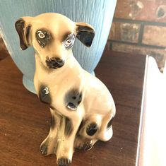 a ceramic dog figurine sitting on top of a wooden table