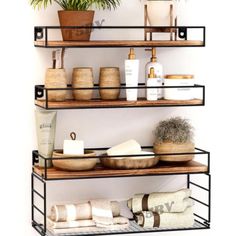 three tiered shelving unit with towels, soaps and other items on it