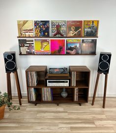 an entertainment center with speakers, record players and records on the wall in front of it