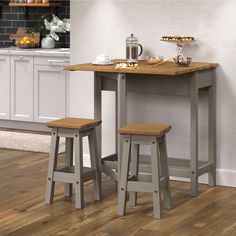 two stools sit at a small table with food on it in front of a kitchen counter