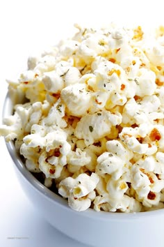 a white bowl filled with popcorn on top of a table