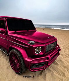 a pink jeep parked on top of a sandy beach