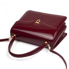 Royale Handbag in Patent Wild Cherry/Black Of true royal pedigree, this bag is a favorite of H. M. Queen Elizabeth II. An elegant blend of linear and curved forms, this piece is wonderfully British. Designed and manufactured by Launer London, this piece is crafted to the highest possible standards. Only the finest calfskin leathers sourced from Italy are used to create this piece. The interior is equally striking and features fine Italian suede linings. While we do not stock these soft leather h Launer Bag, Launer London, Modern Handbag, Statement Handbag, Bag Inspiration, Soft Leather Handbags, Wild Cherry, Purse Brands, Handbag Heaven