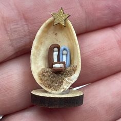 a miniature egg shell with an image of two people in it and a star on top