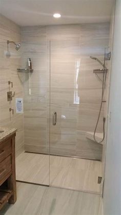 a walk in shower sitting inside of a bathroom next to a sink and counter top