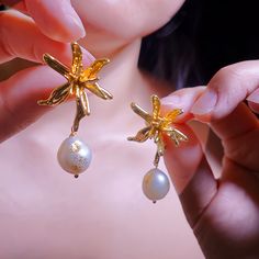 🌟 Dive into oceanic elegance with our 18k Gold Plated Pearl Earrings! 🌟  Are you ready to make a splash this summer? Our earrings aren't just any ordinary jewelry. These fab dangle earrings sport an enchanting starfish and flower design, giving you major tropical vibes. Handcrafted with love, these beauties flaunt lustrous pearls that shimmer like the sea. They are perfect for beachy outings, sun-kissed weddings, or just because you want to feel like a queen! 💖 Bonus: They make the ultimate " Elegant Starfish Charm Drop Earrings, Elegant Handmade Starfish Earrings, Elegant Flower Shaped Earrings For Beach, Elegant Flower-shaped Earrings For Beach, Gold Elegant Earrings With Starfish Charm, Elegant Gold Earrings With Starfish Charm, Elegant Dangle Flower Earrings For Beach, Elegant Starfish Charm Earrings For Gift, Elegant Starfish Charm Earrings As Gift