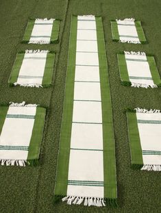 green and white table runneres laid out on the ground with tasselled edges