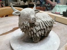 a sculpture of a horned animal on a wooden table