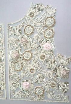 two pieces of white lace with pink flowers on them