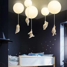 a bedroom with black walls and white lights hanging from it's ceiling above the bed