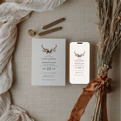 wedding stationery with deer antlers on it and ribbon tied to the front, along with other items