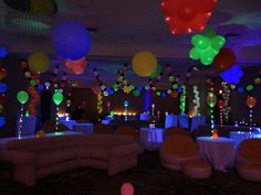 a room filled with lots of balloons and tables