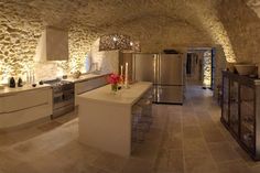 a large kitchen with stone walls and flooring