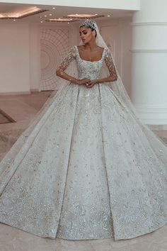 a woman in a wedding dress standing on the floor with her hand on her hip