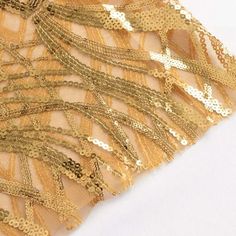 Gold Wave Sequin Sash Introducing a touch of opulence to your event decor, our Wave Embroidered Sequin Mesh Chair Sashes Bands are a captivating addition that elevates ordinary seating into extraordinary elegance. Crafted with meticulous attention to detail, these sashes seamlessly blend the richness of gold, creating a dynamic visual interplay that catches the eye and adds a touch of luxury to any occasion. The intricate wave embroidery, delicately woven with sequins on a mesh base, brings a textured depth that shimmers and dances with every movement. Gold Embroidered Sequin Mesh Sash Enhance the ambiance of weddings, galas, and celebrations with these chair sashes that go beyond mere accessoriesthey are works of art that transform chairs into stunning focal points. Each sash features a p Gold Sequined Embroidered Fabric For Party, Glamorous Gold Sequin Fabric For Banquets, Gold Sequin Fabric For Banquet, Gold Embroidered Sequin Fabric For Party, Gold Embroidered Fabric With Sequins For Party, Glamorous Gold Sequin Fabric For Banquet, Gold Embroidered Fabric For Festive Ceremony, Gold Embroidered Fabric For Ceremony And Festive Occasions, Festive Gold Embroidered Fabric For Ceremony