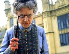 an old woman holding a pipe in front of a building with tall towers and windows