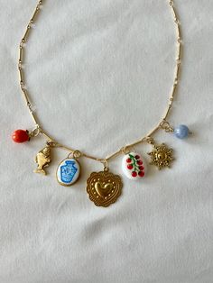 Inspired by the sweet lull of summertime, this charm necklace features a medly of  handmade clay, natural stone, and vintage brass and pewter charms.  Measurements: The 18KT gold-plated brass chain measures 16.5" plus a 2" chain extender.  Important Care Instructions: To ensure the longevity of your necklace, avoid exposure to excess moisture, and do not wear it in the shower or swimming pool. Also, I incorporate vintage raw brass charms in my designs. Brass and similar alloys develop an antique patina over time. If you prefer a shiny look, you can polish the charms with brasso. Charm Necklace Vintage, Handmade Charm Necklace, Clay Charm Necklace, Charm Tattoo, Necklace Clay, Gold Charm Necklace, Charm Necklaces, Chain Extenders, Jewelry Lookbook