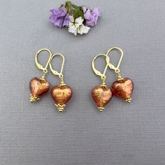 ✦These puffy heart Venetian Murano glass heart earrings make the perfect jewelry gift for her!   ✦Authentic Murano glass Heart in transparent Murano glass in a beautiful Rubino pink and red color over 24kt gold foil with gold daisy spacers or fancy crown detailing adorning the hearts, as shown in several pictures.  ✦The hearts measure 12mm in length. 14k gold-filled French hook or lever back ear wires. ✦Please select ear wire style and simple daisy spacer or fancy crown detailing at check out. ✦Want to upgrade your earrings with solid 14k gold ear wires? Click here to purchase the upgrade: https://www.etsy.com/listing/1198680050 ✦Need to convert your earrings to clip-on, non-pierced ear wires? Click here to purchase the upgrade: https://www.etsy.com/listing/706005409 ✦Click here to see my Handmade Heart-shaped Orange Jewelry, 14k Gold-filled Heart Earrings For Gift, Handmade Murano Glass Earrings For Gift, Gold Murano Glass Jewelry Gift, Murano Jewelry, Elegant Gold Murano Glass Earrings, Diy Jewelry Projects, Puffy Heart, Leverback Earrings