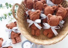 a basket filled with brown teddy bears sitting on top of a table next to plates and utensils