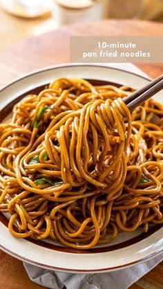 a plate full of noodles with chopsticks on the side and an advertisement for noodle