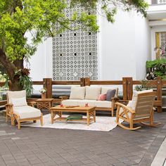 an outdoor patio with wooden furniture and potted plants