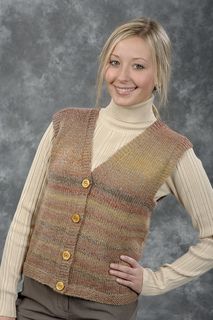 a woman standing in front of a gray background wearing a sweater and pants with buttons