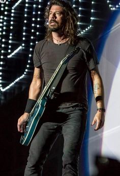 a man with long hair holding a guitar