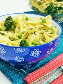 a blue bowl filled with pasta and broccoli on top of a place mat