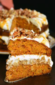 a slice of carrot cake with cream cheese frosting and walnuts on the top