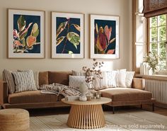 a living room filled with furniture and pictures hanging on the wall above a coffee table