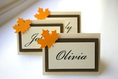 three place cards with autumn leaves on them