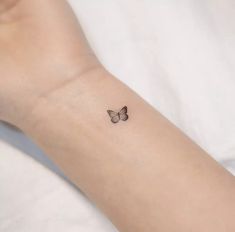 a small butterfly tattoo on the wrist