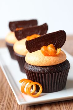 two cupcakes on a plate with orange slices