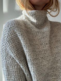 a woman with blonde hair wearing a turtle neck sweater